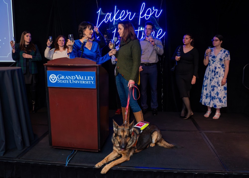 Group of people on stage with service dog